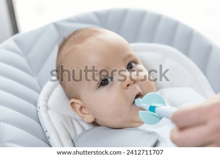 Newborn baby suffering of his tooth growth, mom using a teether to ease the pain, healthcare concept