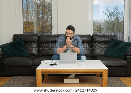 A stressed man deep worried thinking while working on a laptop at home. Royalty-Free Stock Photo #2412714029
