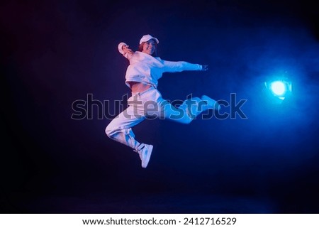a girl in light clothes dances on a neon background in smoke, modern dance