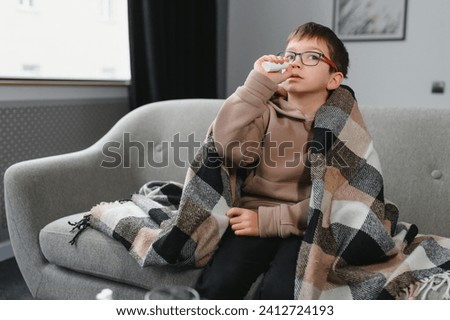 Ill little boy with sore throat at home.