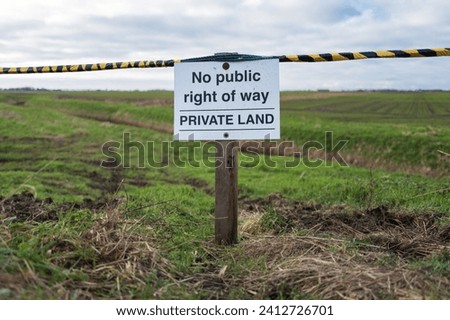 Private Lan sign seen at the entrance to a large farm field. The notice and barricade are to stop walkers drifting off from the adjacent public footpath in a nature reserve.