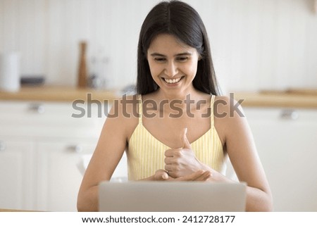 Smiling young woman with disability looks at laptop screen communicates to friend, family or learner lead personal talk teaching, show signs, hands gestures, make videocall by business, on-line class Royalty-Free Stock Photo #2412728177