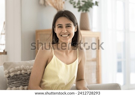 Portrait of attractive woman smile look at camera sit on cozy sofa in living room enjoy day off at home. Profile picture, young owner of flat, renter of modern apartment, tenancy and bank mortgage