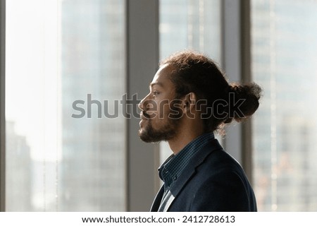 Business vision. Side view portrait of black businessman ceo look at office window ponder visualize think on perspectives. Young biracial male worker in formal suit plan successful career. Copy space