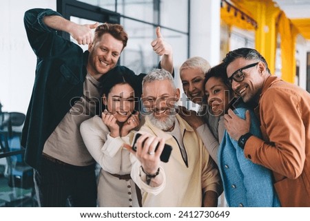 Successful male and female colleagues enjoying friendly cooperation making selfie images on smartphone in office interior, happy group of investors clicking cellphone photos and smiling at camera