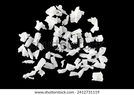 Fresh coconut flakes on black background, top view. Close up Royalty-Free Stock Photo #2412731119