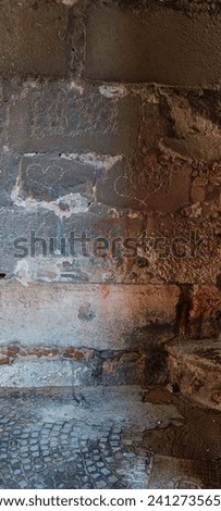 Time-Worn Rebellion: Faded Graffiti on Historic Wall Royalty-Free Stock Photo #2412735659