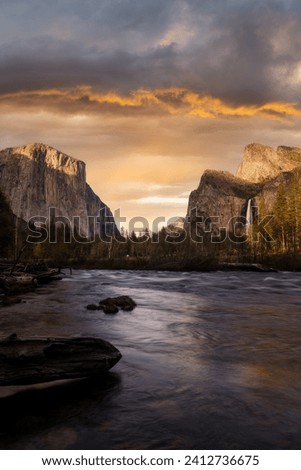 A fine art landscape photography image of Yosemite Valley framed during a vibrant and dynamic Spring sunset with a flowing a dreamy river in the foreground