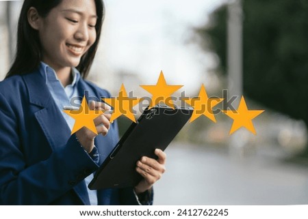 Satisfaction concept. Woman choosing with tick five star rating on Tablet, blurred background.