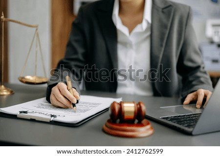 justice and law concept. Male judge in a courtroom the gavel, working with smart phone and laptop and digital tablet computer on desk in office

