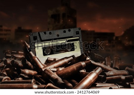 Photo of an old audio tape cassette on pile of bullets. Ruined city wasteland background.