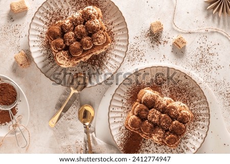 Tradition italian layered dessert tiramisu with mascarpone cream and ladyfingers biscuits sprinkled with cocoa powder on a white background. Top view Royalty-Free Stock Photo #2412774947