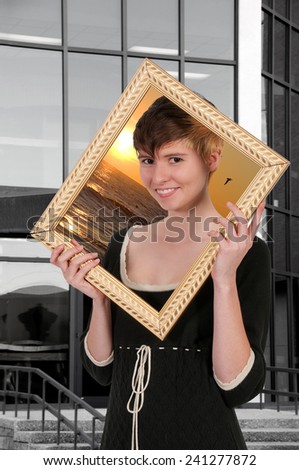 Woman looking through a picture frame dreaming about vacation or holiday