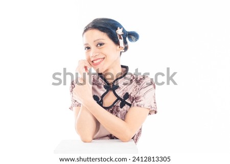 Close up portrait of an attractive Asian Chinese female wearing cheongsam or qipao isolated on white background