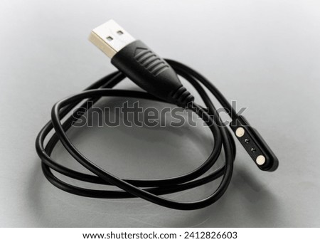 Charging cable for wristwatch on white background Royalty-Free Stock Photo #2412826603