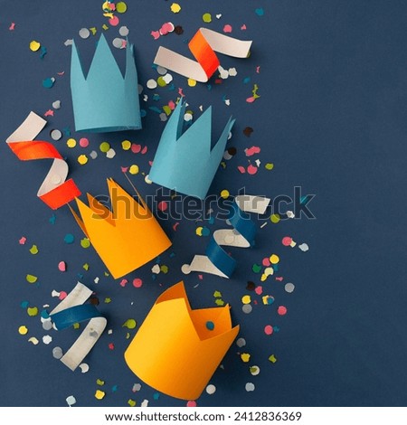 The image features a group of colorful objects, likely made from construction paper, arranged in an artistic display.