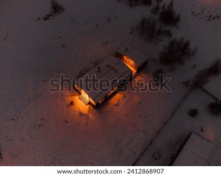 Drone Shot of an Illuminated Hut Covered in Snow.