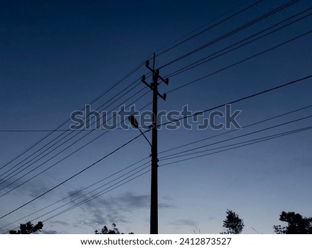Tiang listrik dengan kabel listrik saat matahari terbenam. Transmisi listrik. Royalty-Free Stock Photo #2412873527