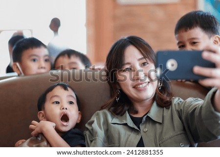 woman takes her children and family on vacation and takes pictures of her family with her cell phone. happy smile indoor
