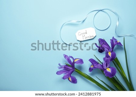 Spring flowers and the inscription "Good morning" on a blue background. The concept of the morning, top view. Flat lay. Space for text.