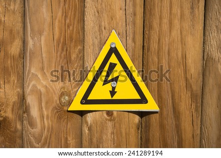 High voltage sign on wood background 