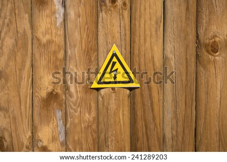 High voltage sign on wood background 
