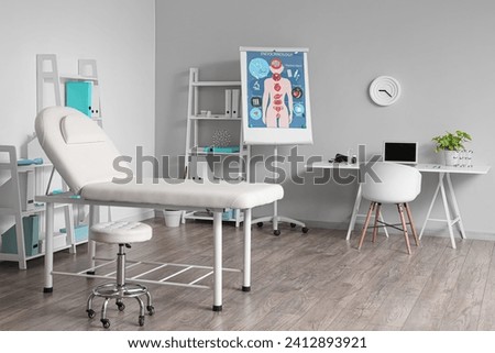 Interior of medical office with workplace, couch and shelf units