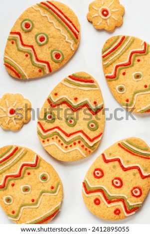 Set of Easter cookies in the form of Eggs, decorated with colored sugar paste. Homemade bakery.  Happy easter holiday concept. White background. Top view. Royalty-Free Stock Photo #2412895055