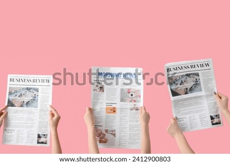 Women with newspapers on pink background Royalty-Free Stock Photo #2412900803