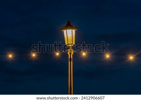 Fairy lights and a lamp post, on Eastbourne promenade Royalty-Free Stock Photo #2412906607