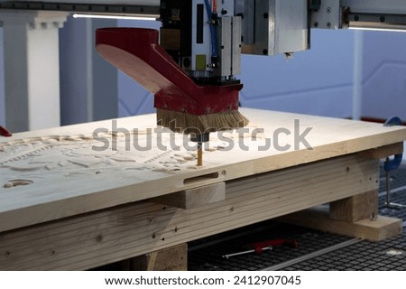 Wooden door manufacturing with CNC router machine. Selective focus. Royalty-Free Stock Photo #2412907045