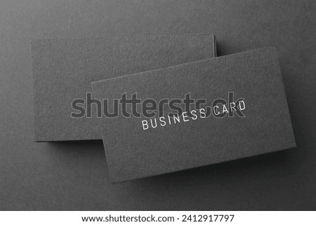 Stack of business cards on black background, top view