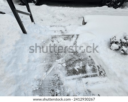 A shoveled staircase with snow still around it after a winter storm.