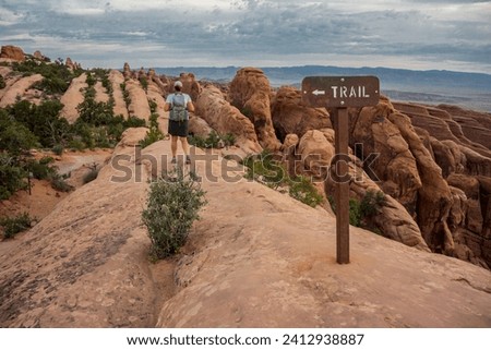 Woman Hikes Down Slickrock in Arches National Park