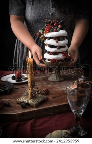 Woman hands holding meringue with fruit
