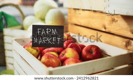 Selection of Tasty Red Apples with a Farm Market Sign on a Food Stall with Fresh Organic Fruits and Vegetables. Outdoors Marketplace Selling Eco-Friendly Biological Produce from Local Farmland