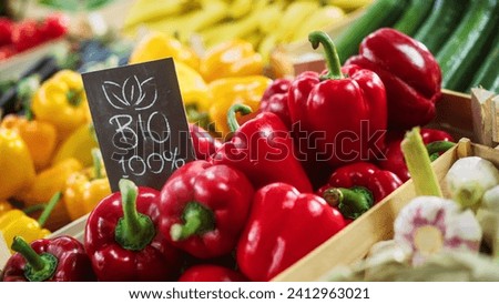 100% Bio Sign on a Food Stall with Fresh Red and Yellow Organic Sweet Bell Peppers from a Local Farm. Outdoors Farmers Market with Organic Fruits and Vegetables Without GMO Additives