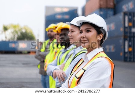 Group of worker wearing safety helmet and reflective vest standing in front of containers.