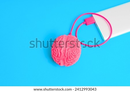 Human brain connected to a power bank, top view. Creative mindful recharge related concept. Royalty-Free Stock Photo #2412993043