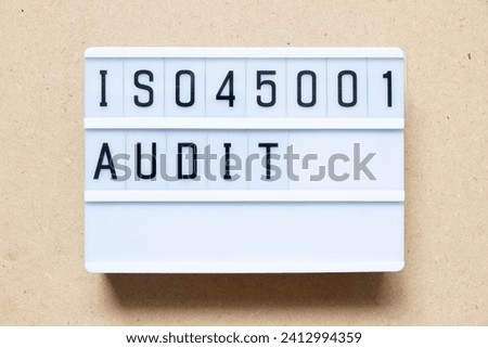 Lightbox with word ISO 45001 audit on wood background