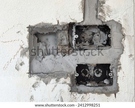 A messy, poorly plastered wall used for installing wall-mounted switches and electrical outlets.