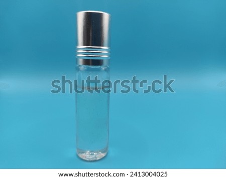 Glass bottle for storing perfume liquid on blue background