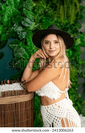 Woman in Bikini and Hat Poses for Picture. A woman wearing a bikini and hat strikes a pose for a photograph.
