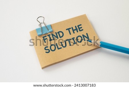 Find The Solution text on notebook with office supplies on white desk