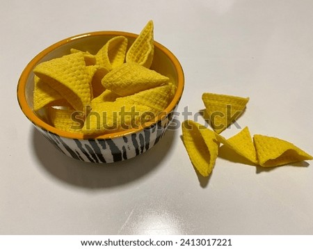 yellow potato chips on white background and in plate