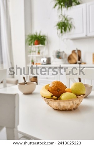 object photo of contemporary kitchen with fresh fruits on table and blurred plants on backdrop