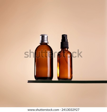 Two cosmetics dark amber glass bottles on beige background. Closeup, copyspace. Beauty blog, salon treatment concept, minimalism brand packaging mock up
 Royalty-Free Stock Photo #2413032927