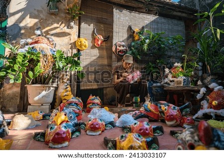 Old man paint on Paper mache mask different animal and characters for celebrate New Year in Viet Nam. Travel concept.