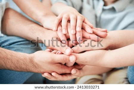 Close-up of several hands placed on top of one another in stack. All family members showing their support to each other. Concept of togetherness, unity, teamwork, family, solidarity, mutual support. Royalty-Free Stock Photo #2413033271
