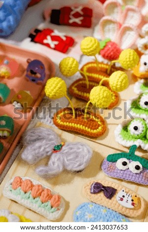 A display of various handmade crocheted animal figurines, including a pink bunny and a green rabbit, creating a visually interesting scene.